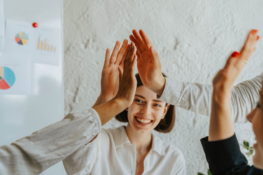 Junge Frauen geben sich ein high-five, Teamwork